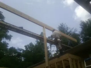 Carpenter setting a ridge beam over a new addition frame — Ice Dam Removal by Roofing Brothers in Mcdaniel