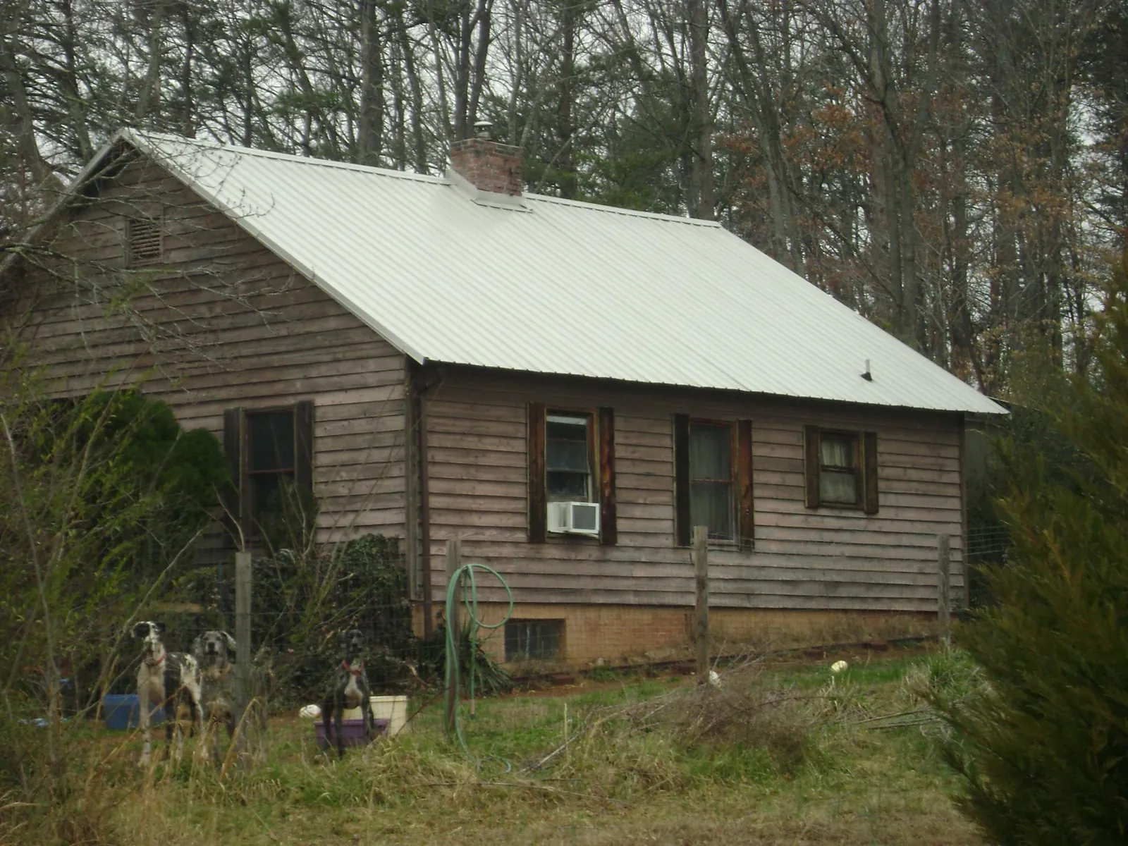 White metal roof on an old wood sided farmhouse, from a Metal Roof Installation job in Mcdaniel